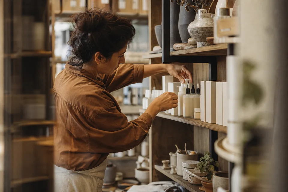 Shop owner placing a newly branded product on a retail shelf